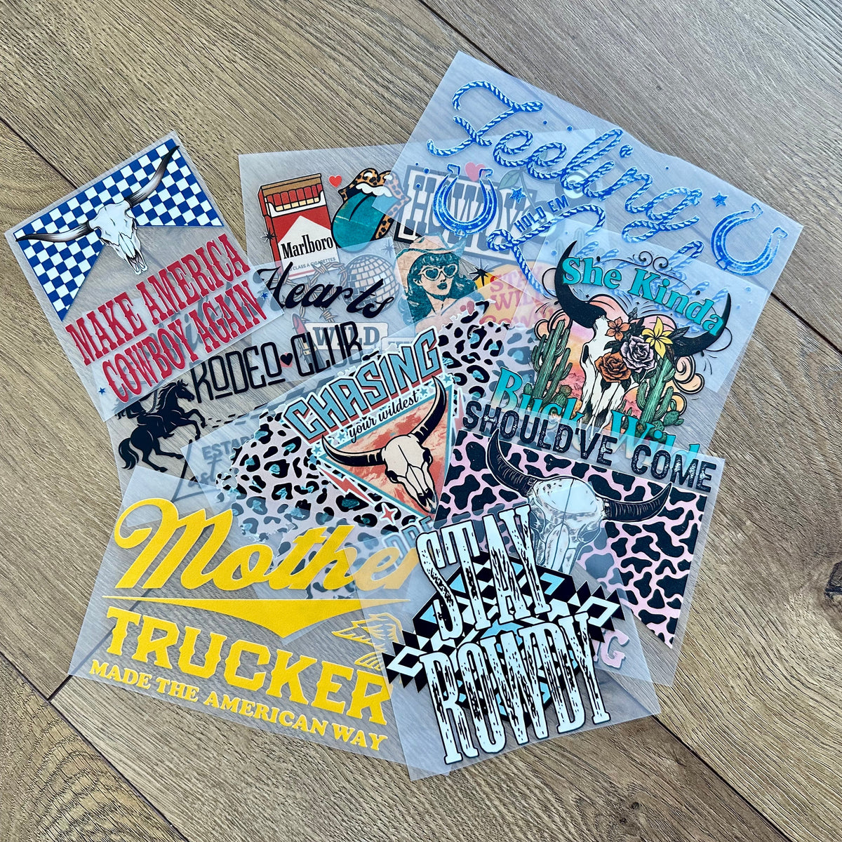 Collection of colorful heat press transfers on a wooden surface